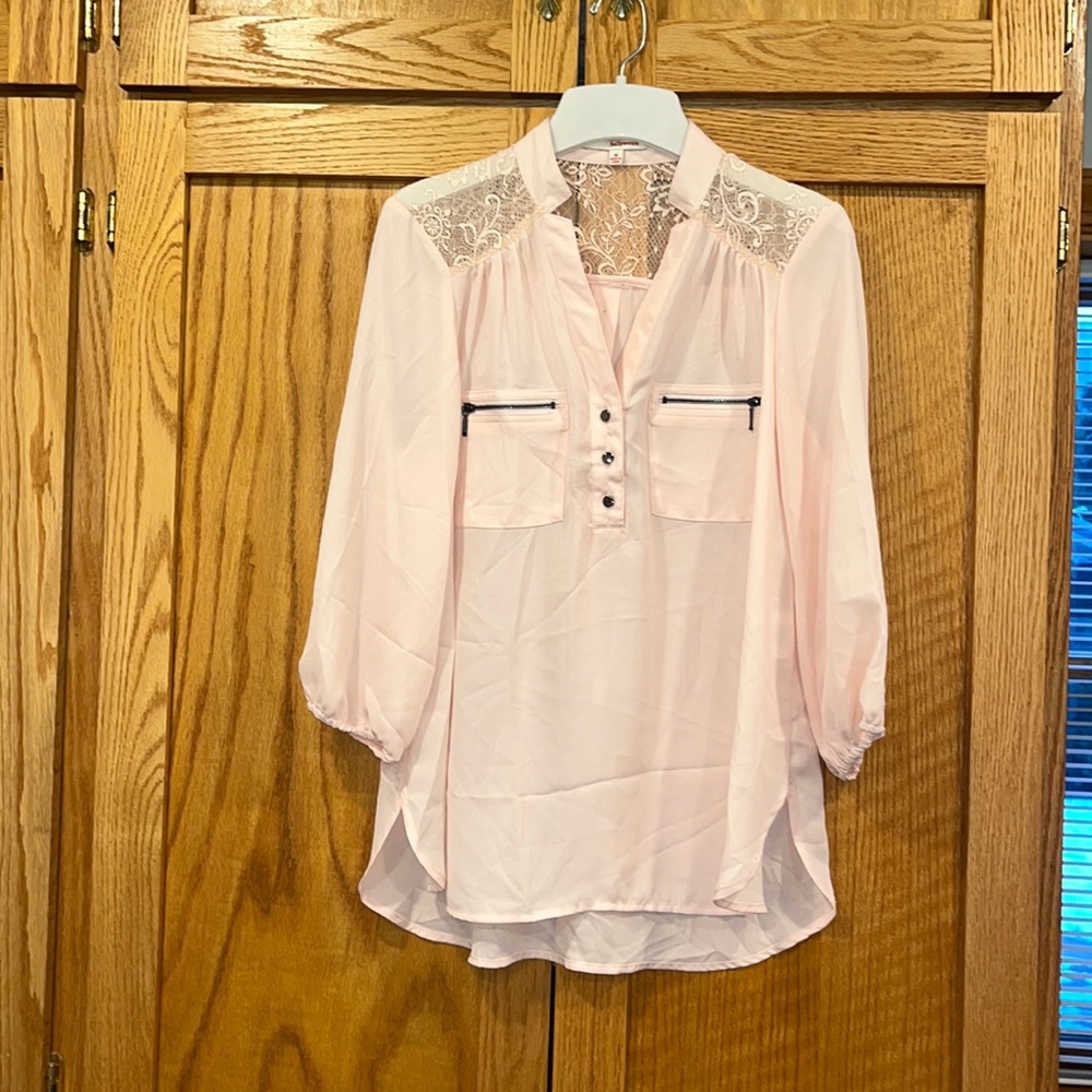 Light pink blouse with button and zipper pocket details with lace on shoulders